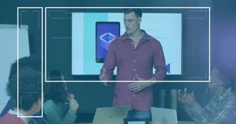 Gesturing maroon-clad presenter presenting tablet interface in meeting room, Stock Photos