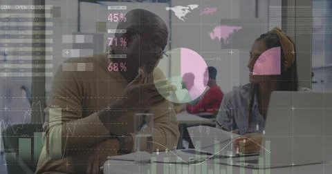 Gesturing mentor in tan sweater explaining data to woman at office round table, Stock Photos