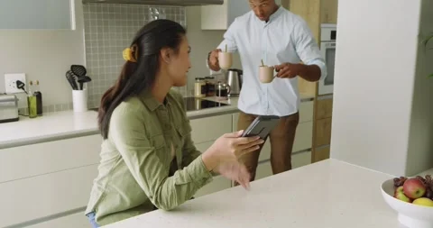 Gesturing over shoulder, Diverse couple pouring water from kettle into mugs Stock Footage 344849962