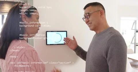 Gesturing senior man in grey sweater showing wall touchscreen in home hallway, Stock Photos