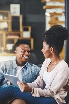 Get comfy and connect. a happy young couple using a digital tablet together on Fotos Stock