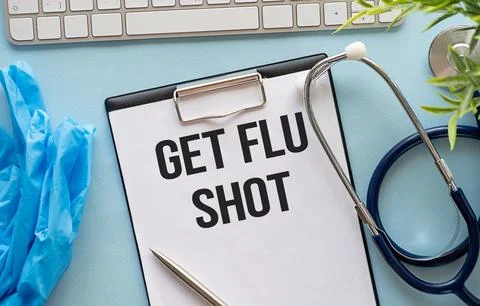 Get the flu shot text on a notebook next to it lies a stethoscope, a medica.. Stock Photos