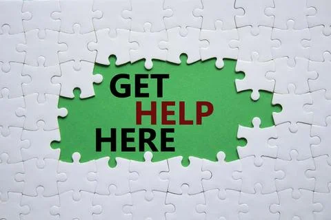 Get help here symbol. White puzzle with words Get help here. Beautiful gree.. Stock Photos