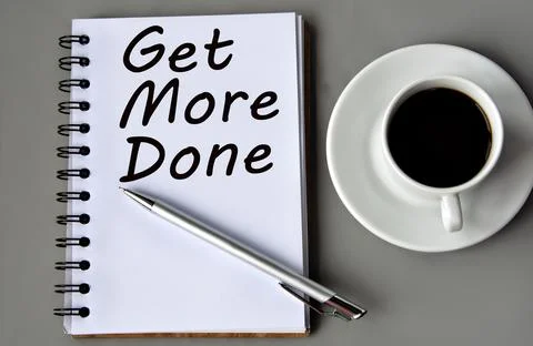 GET MORE DONE - words on a white sheet on a gray background with a pen and .. Stock Photos