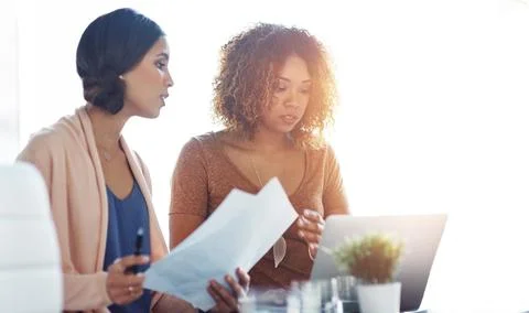 Get proactive, stay productive. two young coworkers going through paperwork and Stock Photos