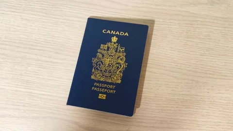 Get Ready to Explore Canada Canadian passport resting on a light wood table, Stockbeeldmateriaal 318311050