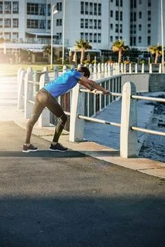 Get ready to get in shape. a young man stretching outside before his run. Stock Photos