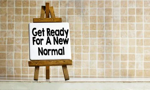 Get Ready For A New Normal Sign On Wooden Easel Against Tiled Wall Stock Photos