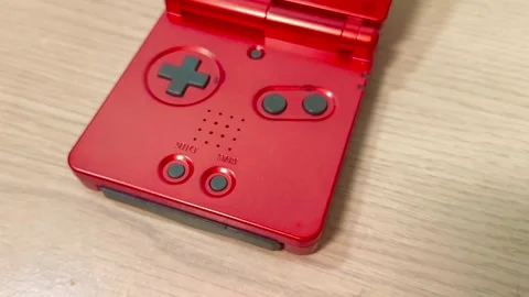 Get ready to play retro games on this vibrant red handheld console, perfect for Video stock 318310939