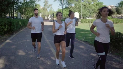 Get in shape after the winter by going for a run in the city park with friend Stock Footage 150116104
