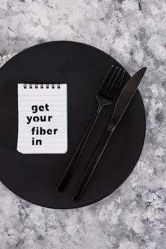 Get your fiber in text on dining plate with fork and knife, healthy nutrition Stock Photos