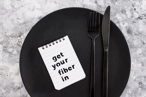 Get your fiber in text on dining plate with fork and knife, healthy nutrition Stock Photos