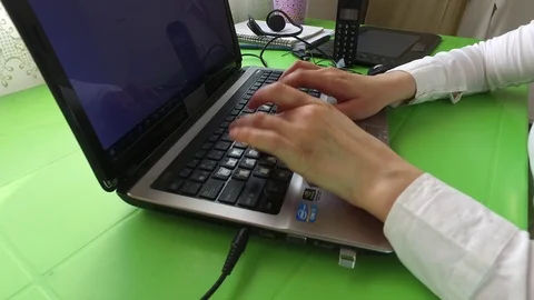 Gets text on the laptop. At the desk. Stock Footage 78042670