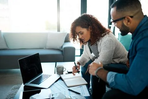 Getting about their household admin. a young couple planning their budget Stock Photos