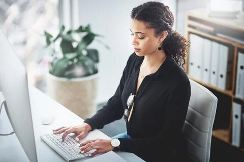 Getting ahead on all her tasks. a young businesswoman working on a computer in Foto stock