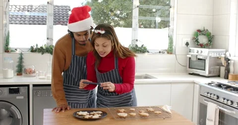 Getting alert, diverse couple scrolling phone over cookies at kitchen counter Vídeo Stock 338167681