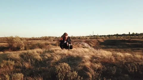 Getting close to a camera operator girl in sunglasses at sunset hills Stock Footage 143558801