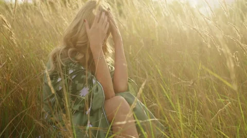 Getting close to a sad beautiful young woman in tears sitting in the deep field Stock Footage 230694260