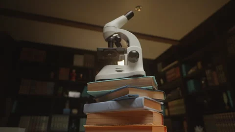 Getting closer to a microscope at the library on a stack of books, HQ 4K footage Stock Footage 259309164