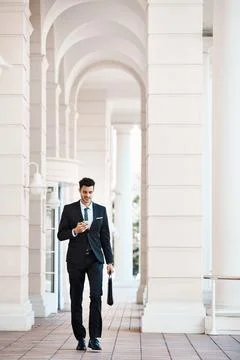 Getting connected the simple way. a young handsome businessman using a cellphone Stock Photos