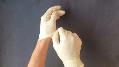 Getting contaminated gloves off safely. Demonstration of how to get hand glov Stock Footage 129975367