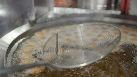 Getting cooked fresh falafel out of oil. Falafel is a famous Meditrranean food Stock Footage 107824254