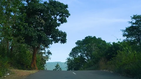Getting down slope from road mountain hills travel green trees video Stock Footage 98587465