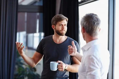 Getting down to some serious conversation. two handsome businessmen having a Stock Photos