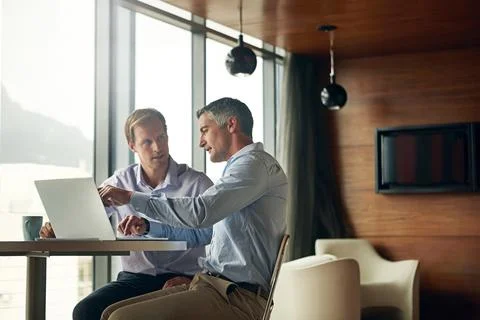 Getting a few pointers from the boss. two businessman talking together over a Stock Photos