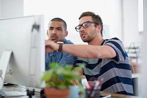 Getting a few pointers. Shot of two colleagues having a discussion at their c Foto stock