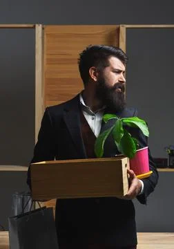 Getting fired. Last day at work. Dismissed employee leaves office with box of Stock Photos