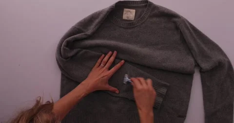 Getting fuzz off of a sweater with a razor blade Stock-Footage 132219076