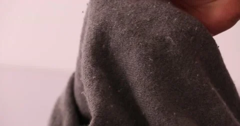 Getting fuzz off of a sweater with a razor blade Stock-Footage 132219118