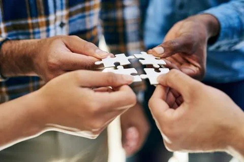 Getting hands on in the problem solving process. a work group connecting pieces Stock Photos