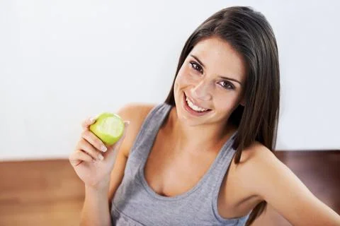 Getting healthy one bite at a time. Portrait of an attractive young woman eating Stock Photos
