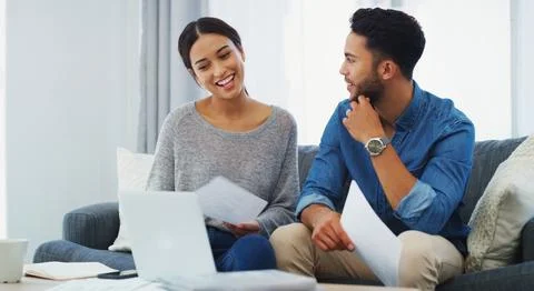 Getting her to explain her spending habits. a happy young couple sitting on the Stock Photos