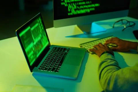 Getting up to no good in the dark. an unrecognizable hacker cracking a computer 스톡 사진