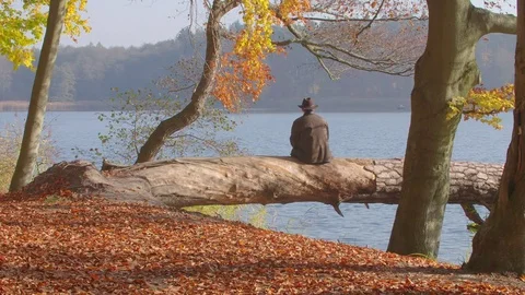 Getting Old, a Mid Aged Man looking to the end of a Autumnal Lake Видео 76694590