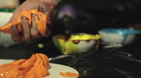 Getting orange ink on hand Stock Footage 30484087