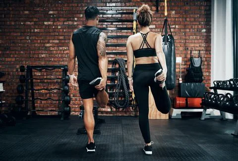 Getting our bodies into shape. two sporty young people working out together at Stock Photos