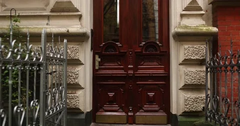 Getting out of gated old german building with scary elegant wooden door Stock Footage 230488933