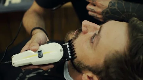 Getting perfect shape. Close-up side view of young bearded man getting beard Stock Footage 69766182