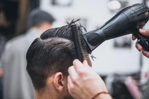 Getting perfect shape. Close-up side view of young bearded man getting beard  Stock Photos