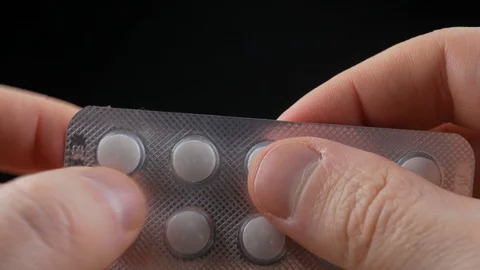Getting a pill out of blister packaging. Macro video Stock Footage 100194840