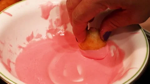 Getting pink icing on a donut hole Stock Footage 135705387