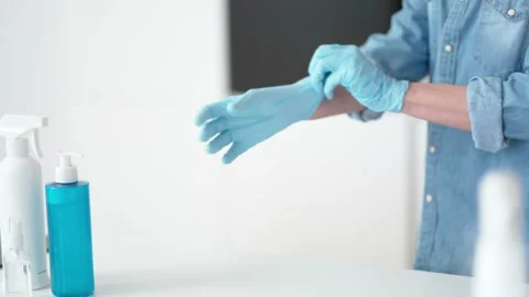 Getting ready for cleanup. Close up of hands of housewife putting on her Stock Footage 149668776