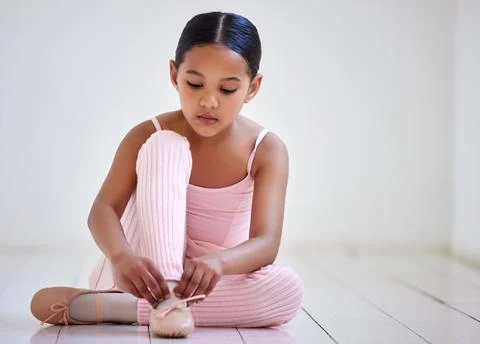 Getting ready to dance the day. a little girl putting on her shoes in a ballet Stock Photos