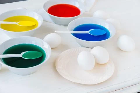 Getting ready for Easter with liquid food coloring. Different colors in diffe Stock Photos