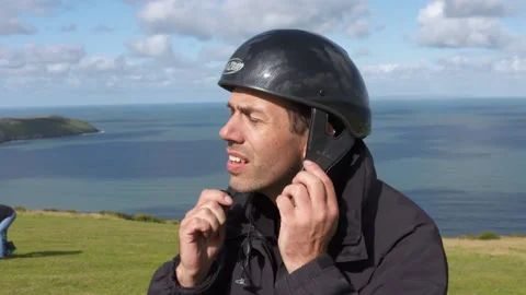 Getting ready to go paragliding, putting on a helmet 스톡 동영상 171283759