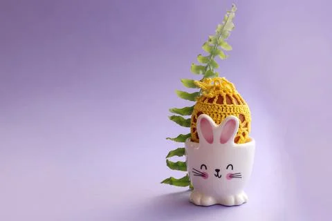 Getting ready for the holiday: an egg decorated with yellow yarn in a stand i Stock Photos